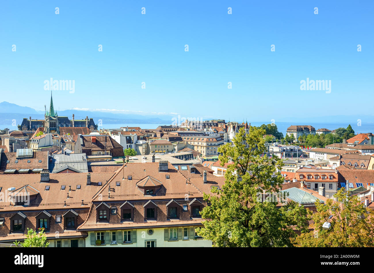 Beautiful cityscape of Lausanne, Switzerland photographed from view point above the city. Geneva Lake and mountains in the background. Historical buildings, Swiss city. French speaking Switzerland. Stock Photo