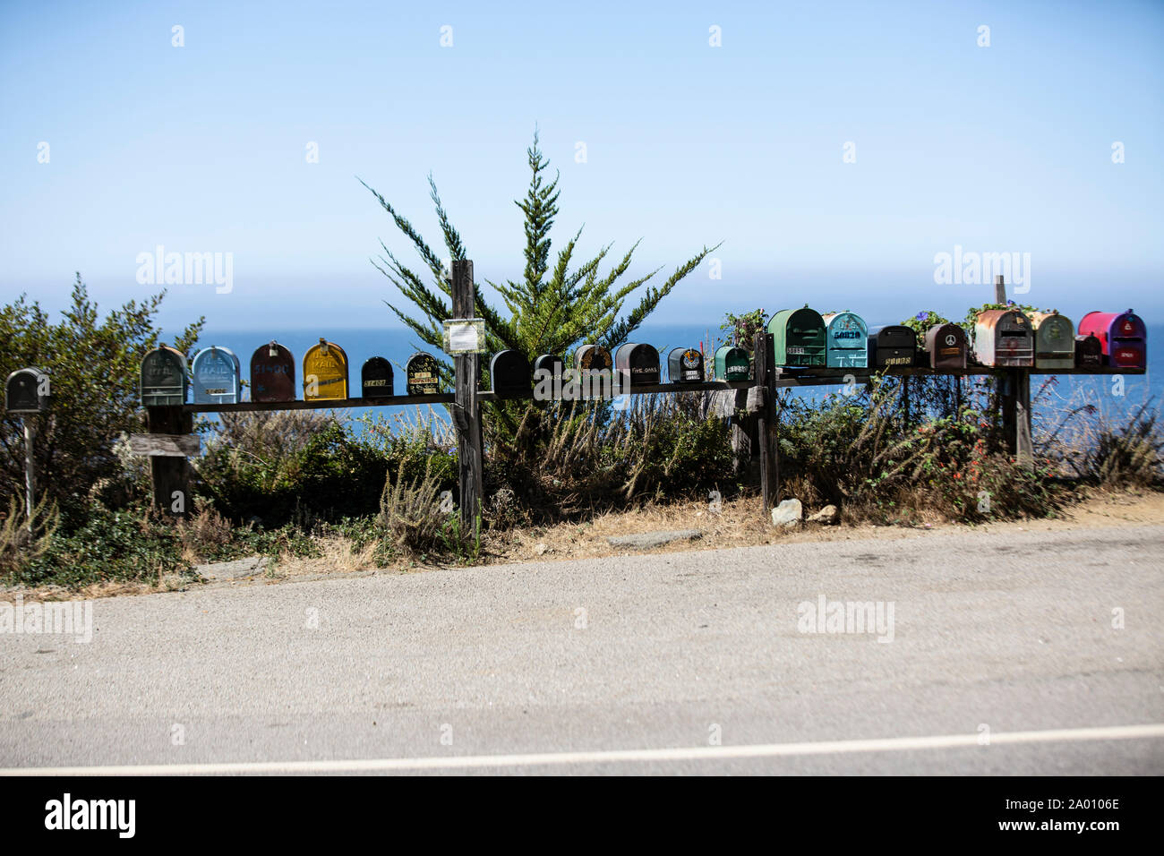 Knallbunte Briefkästen stehen am Highway Nr. 1 in Kalifornien, im Hintergrund der pazifische Ozean. Der Highway ist hier im Bereich Big Sur eine traum Stock Photo