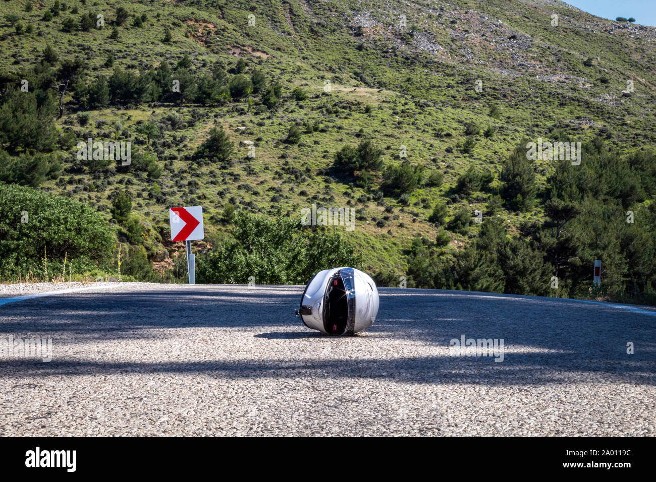 A helmet in the middle of the asphalt road there was a terrible accident Stock Photo