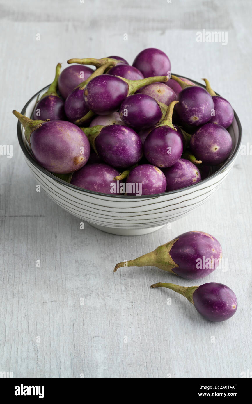 Bowl with fresh raw purple mini eggplants as a snack Stock Photo