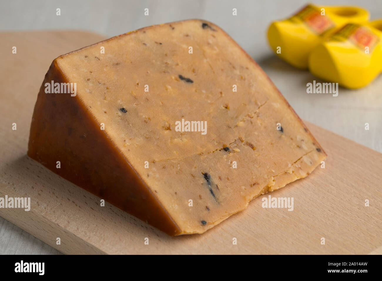 Piece of Dutch very mature Frisian Clove Cheese on a cutting board Stock Photo