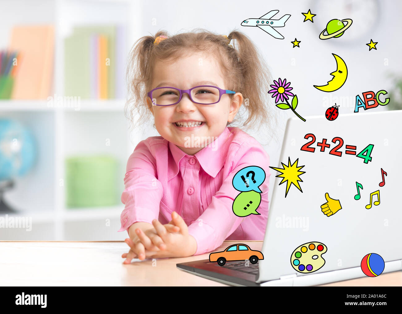 Pleasured kid using notebook actively with great interest as multimedia encyclopedia and for playing Stock Photo