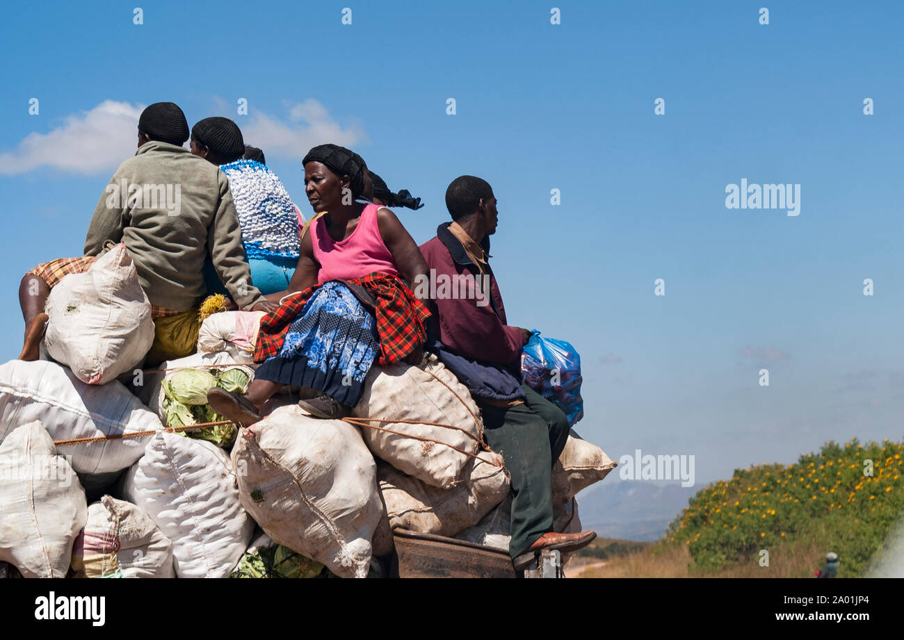 Group of people in Malawi perched on sacks on the back of a lorry Stock Photo