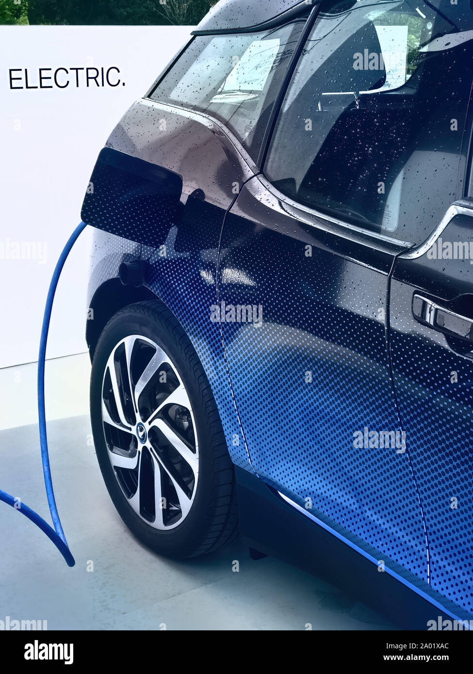 Electric vehicle being plugged in Stock Photo - Alamy