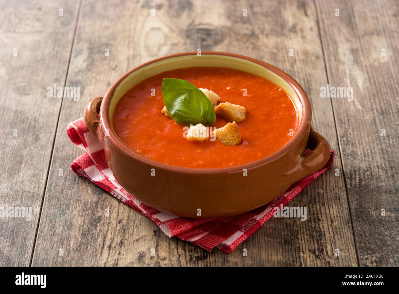 Tomato soup in brown bowl on wooden table Stock Photo