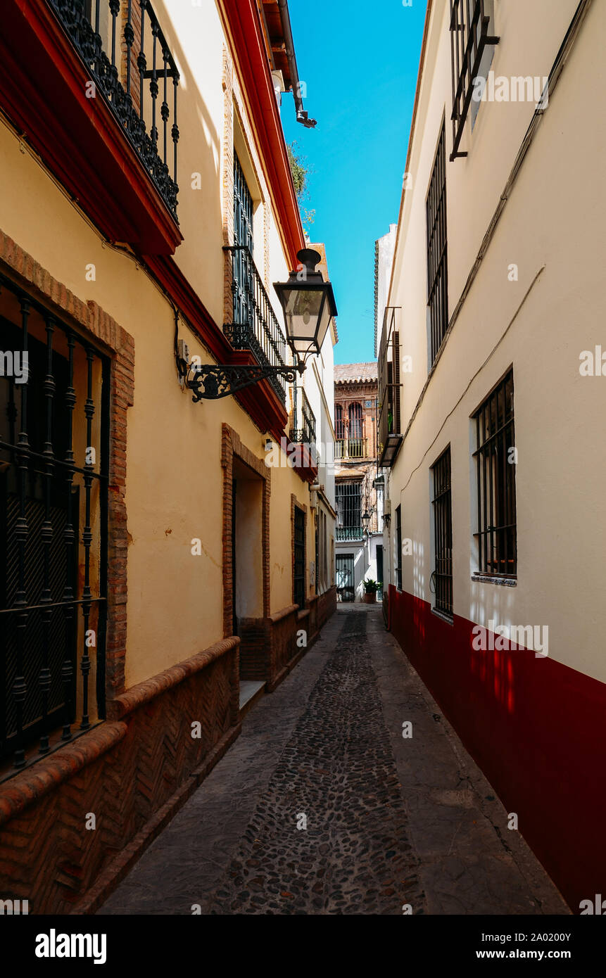 Old picturesque passageway in the medieval Jewish Quarter of Santa Cruz in Seville, Andalusia, Spain. Stock Photo