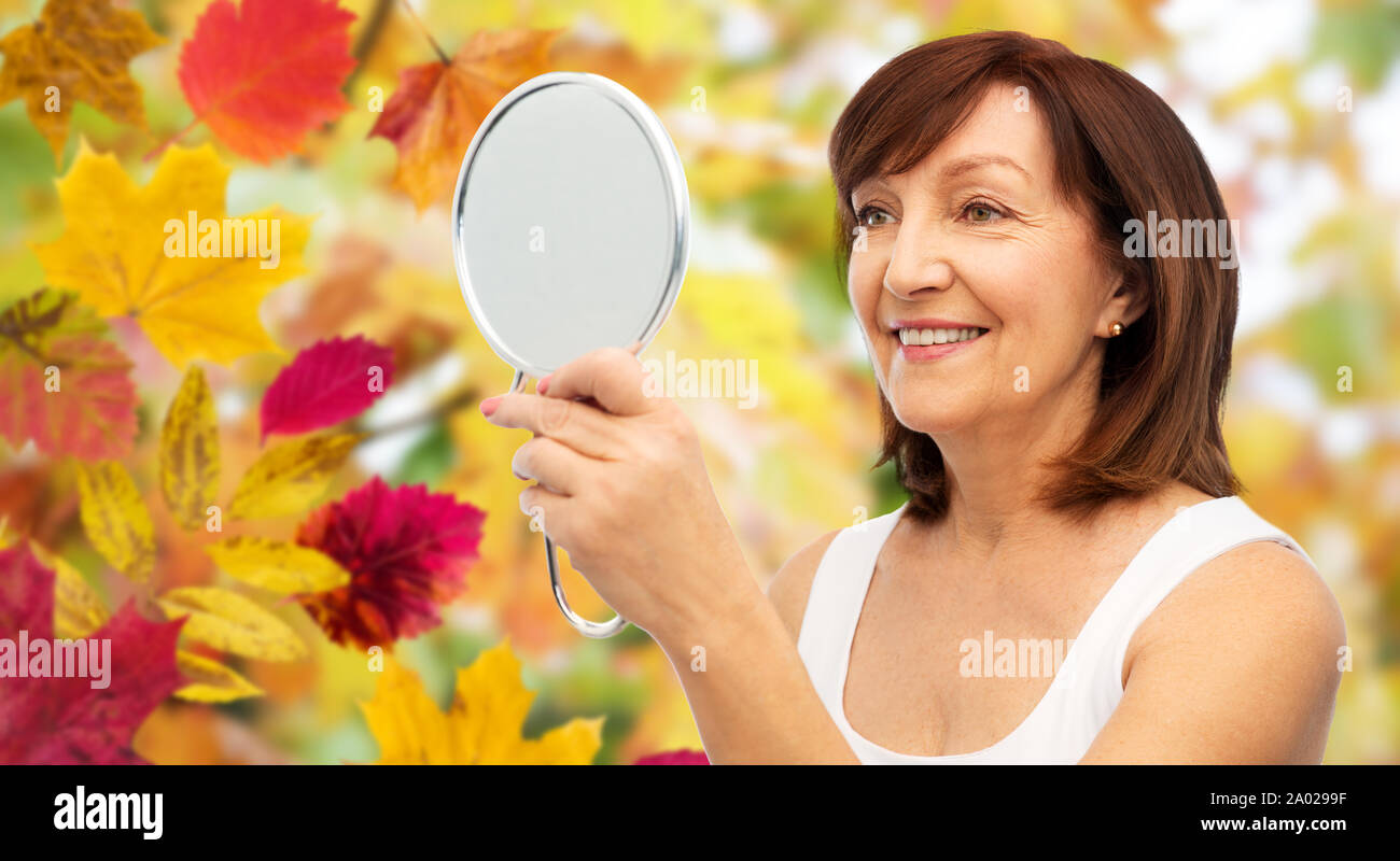 portrait of smiling senior woman with mirror Stock Photo