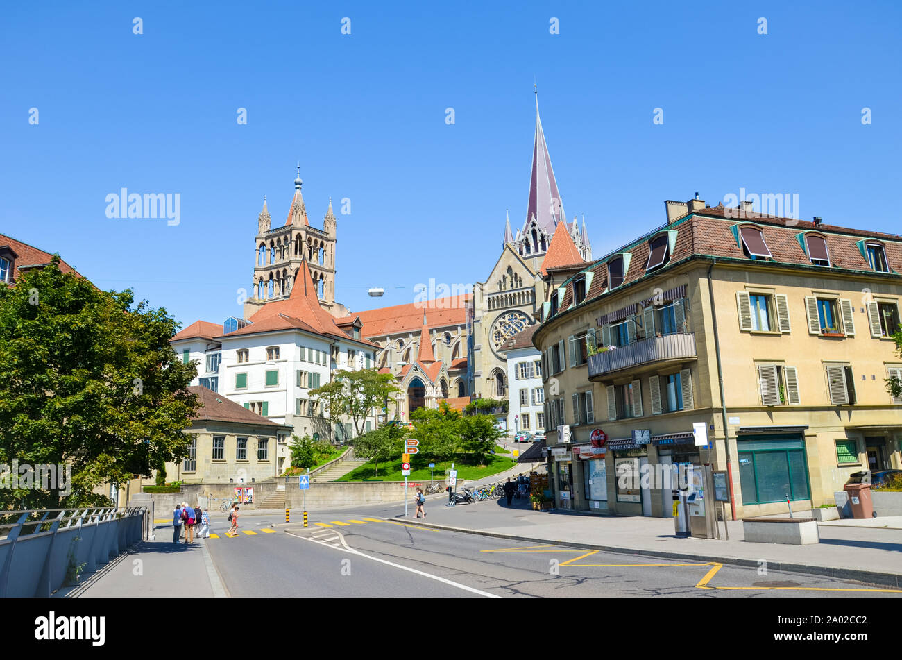 Lausanne, Switzerland - August 11, 2019: The historical center of the French-speaking Swiss city with dominant Notre Dame Cathedral photographed from the adjacent bridge. People on the street. Stock Photo