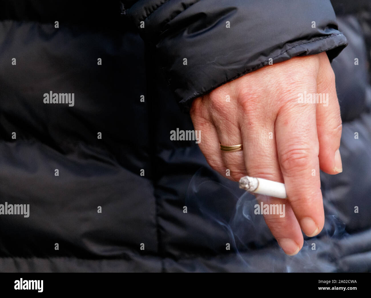 Cambre / Spain - April 19 2019: Hand of a woman holding a cigarette on the street in Spain Stock Photo