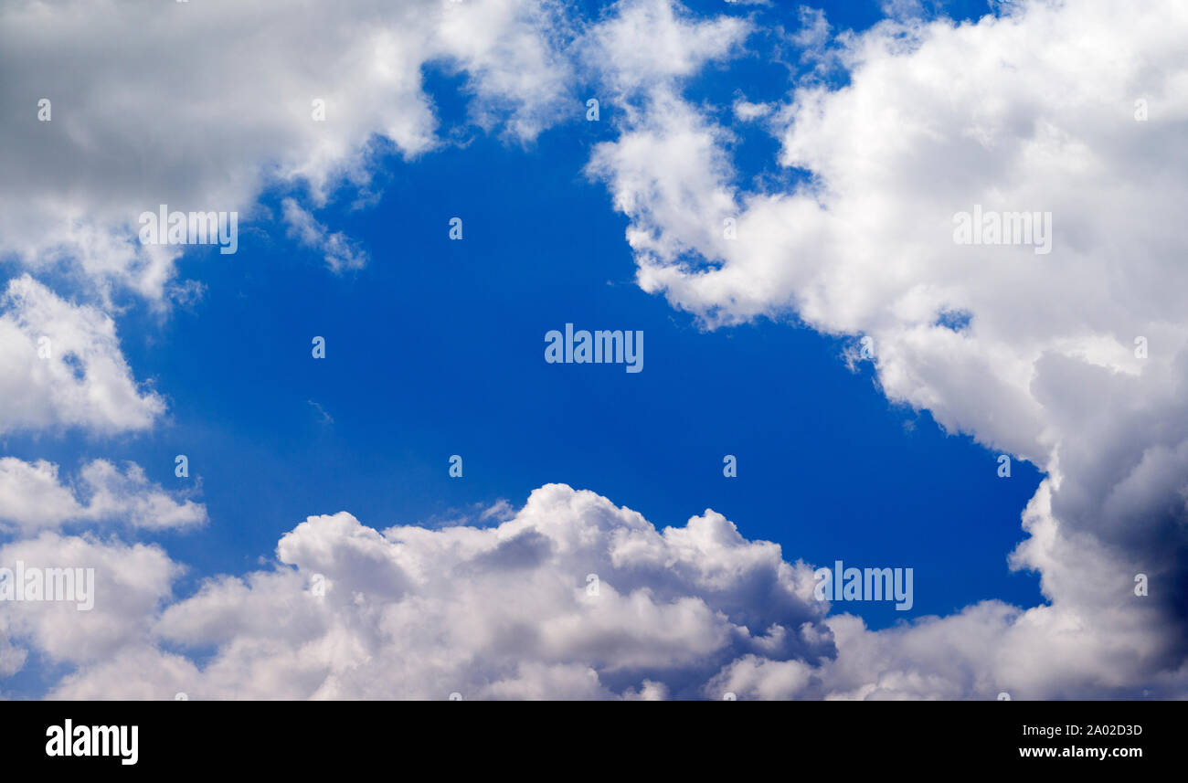 Blue sky gap between cumulus clouds Stock Photo