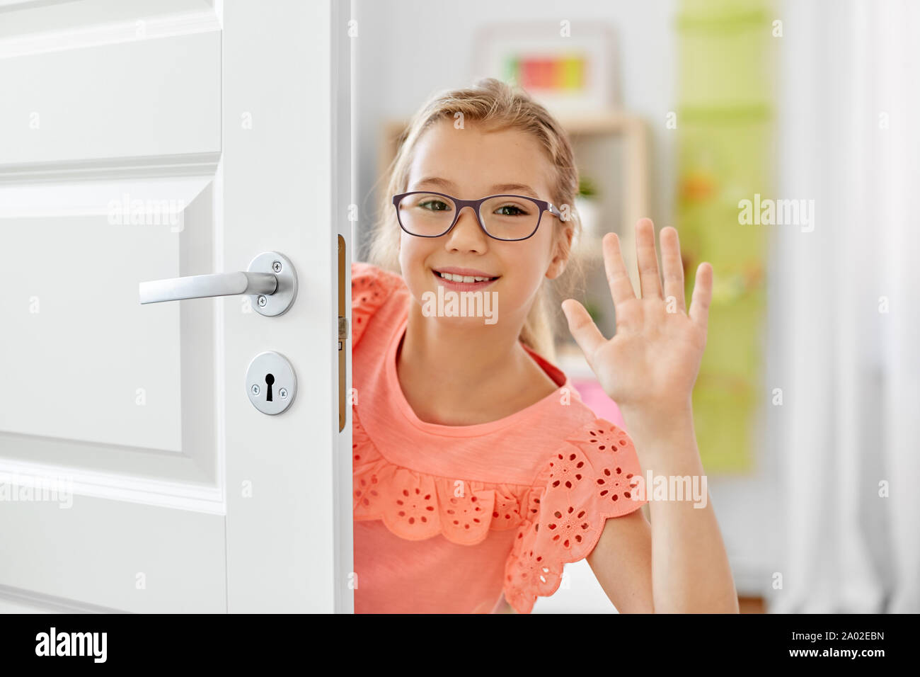 happy smiling beautiful girl behind door at home Stock Photo