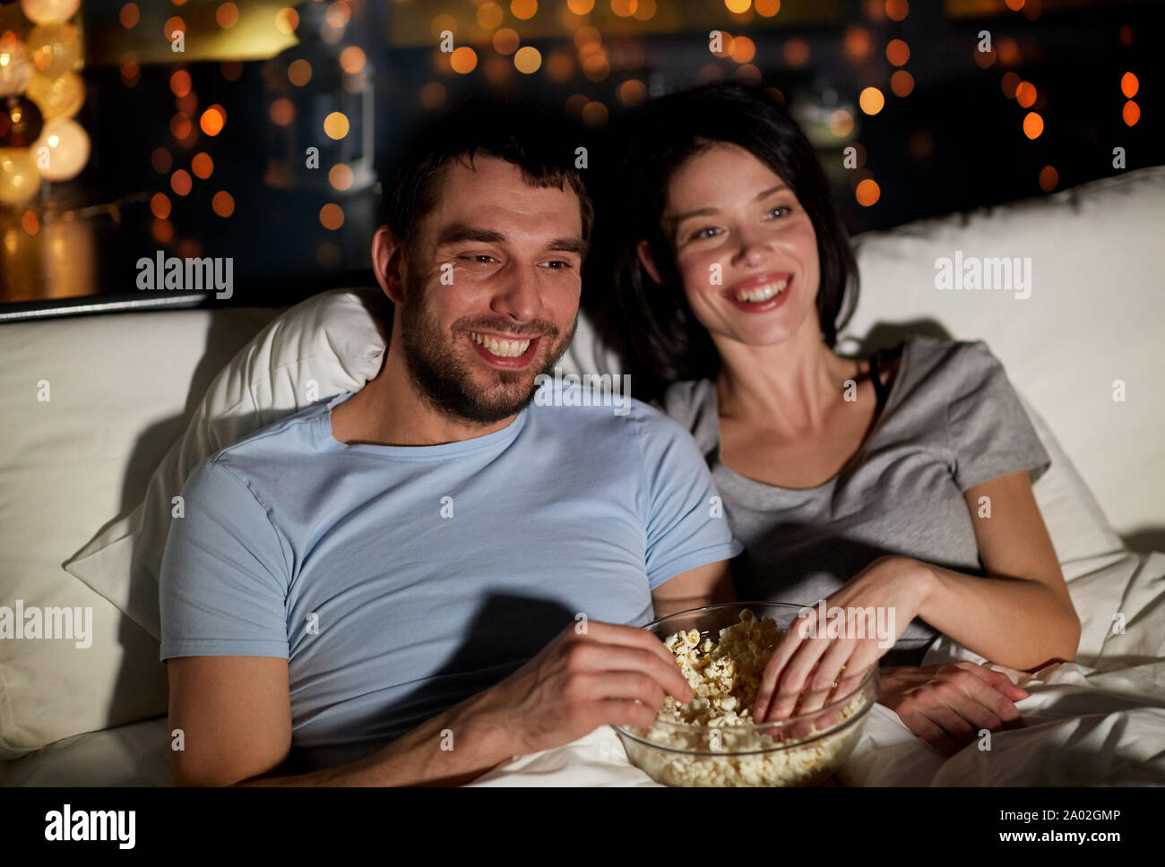 couple with popcorn watching tv at night at home Stock Photo - Alamy