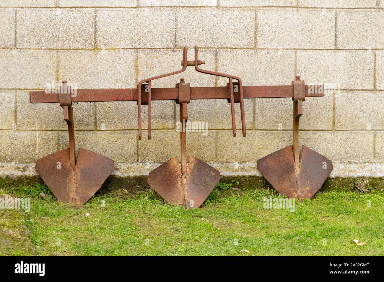 Rusty three blade plough attachment in Cambre Spain Stock Photo