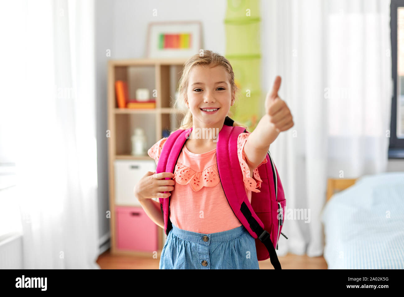 student girl with school bag showing thumbs up Stock Photo - Alamy