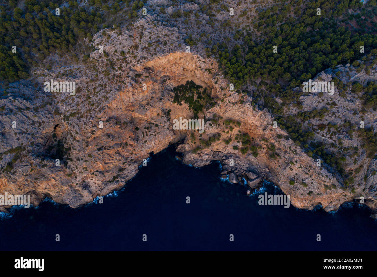 An aerial view of the dramatic Mallorcan coastline. High detail of the sunset lighting on the cliffs and trees. Stock Photo