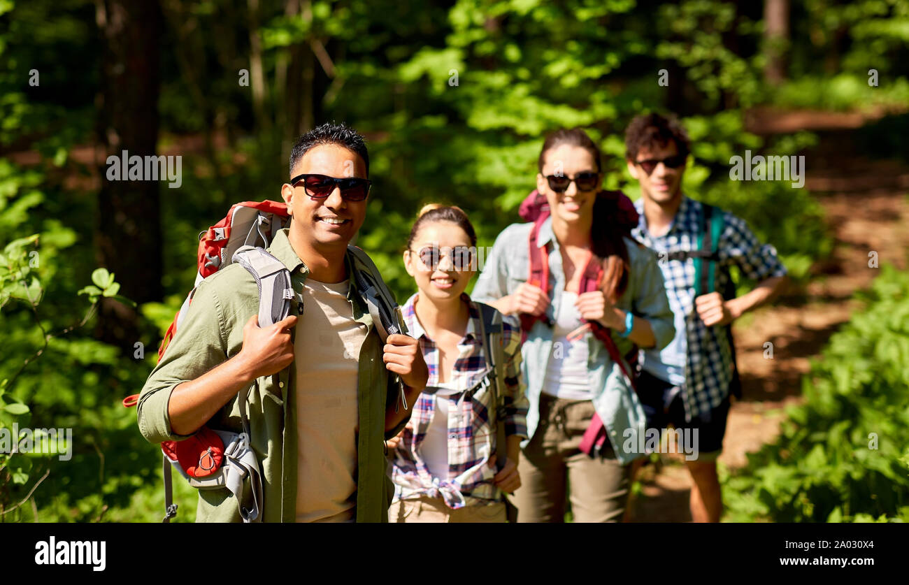 group of friends with backpacks hiking in forest Stock Photo - Alamy
