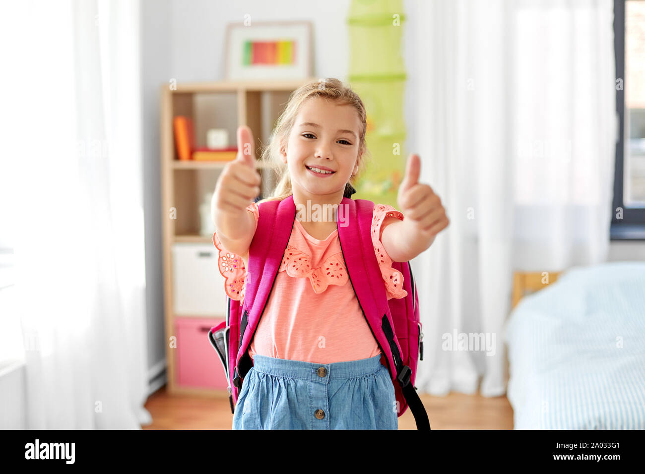 student girl with school bag showing thumbs up Stock Photo - Alamy