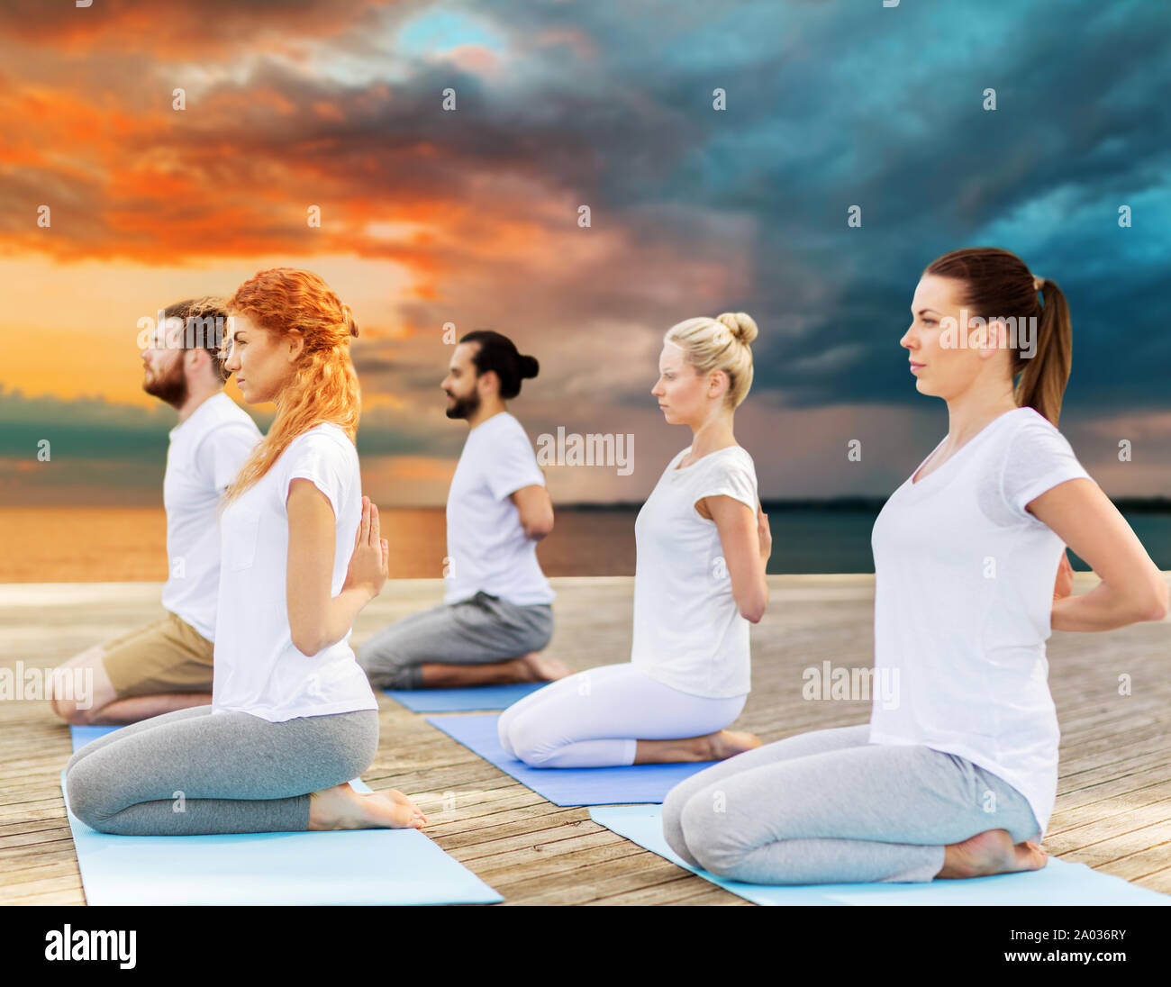 people making yoga in hero pose outdoors Stock Photo