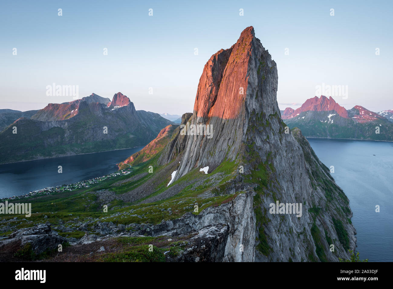 View from Mount Hesten on Iconic Mountain Segla in light of midnightsun with clear sky and mountain range in background, Fjordgard, Senja, Norway Stock Photo