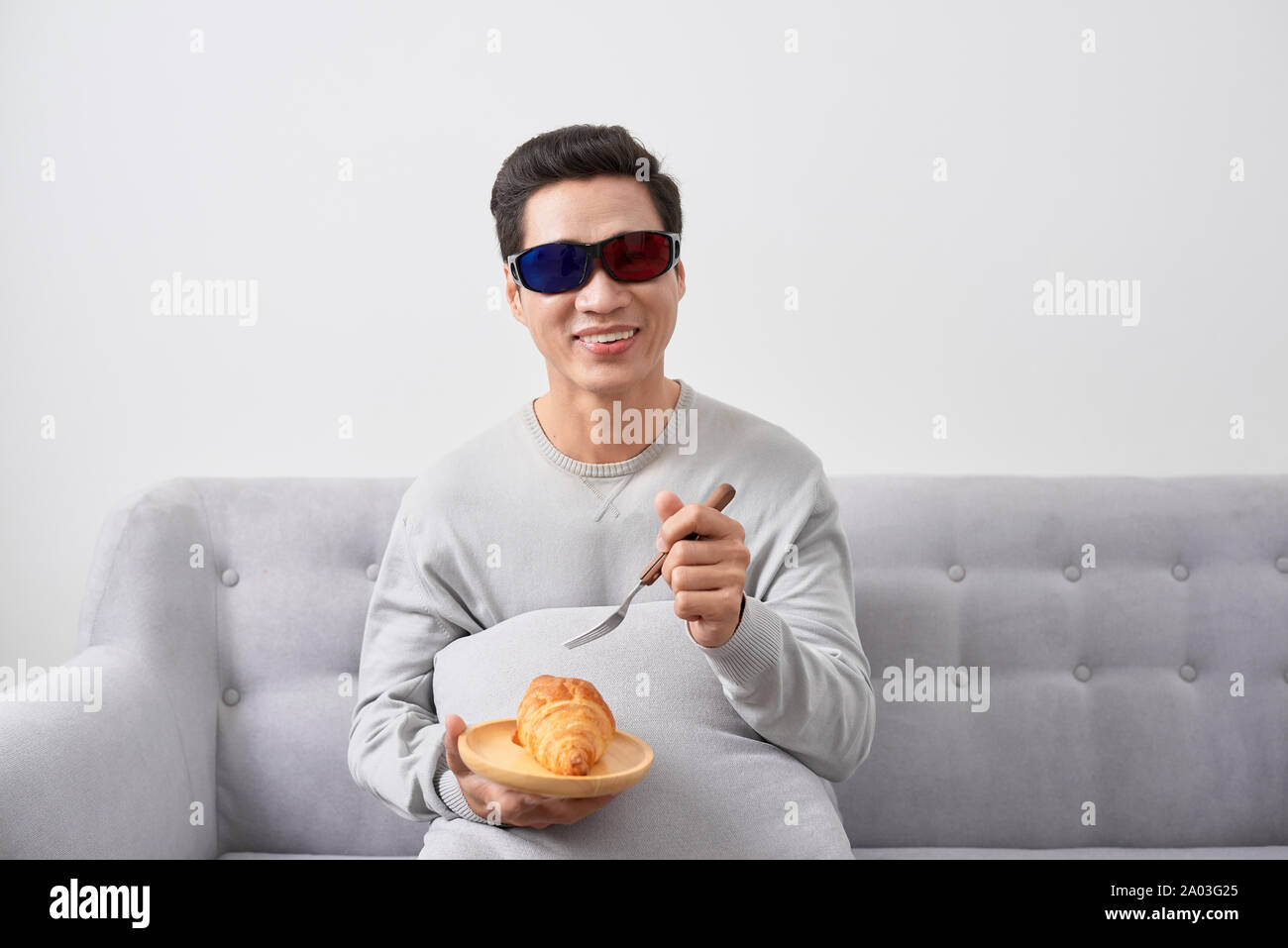 exciting young man watch three-dimensional LCD TV with eye glass in a living room Stock Photo