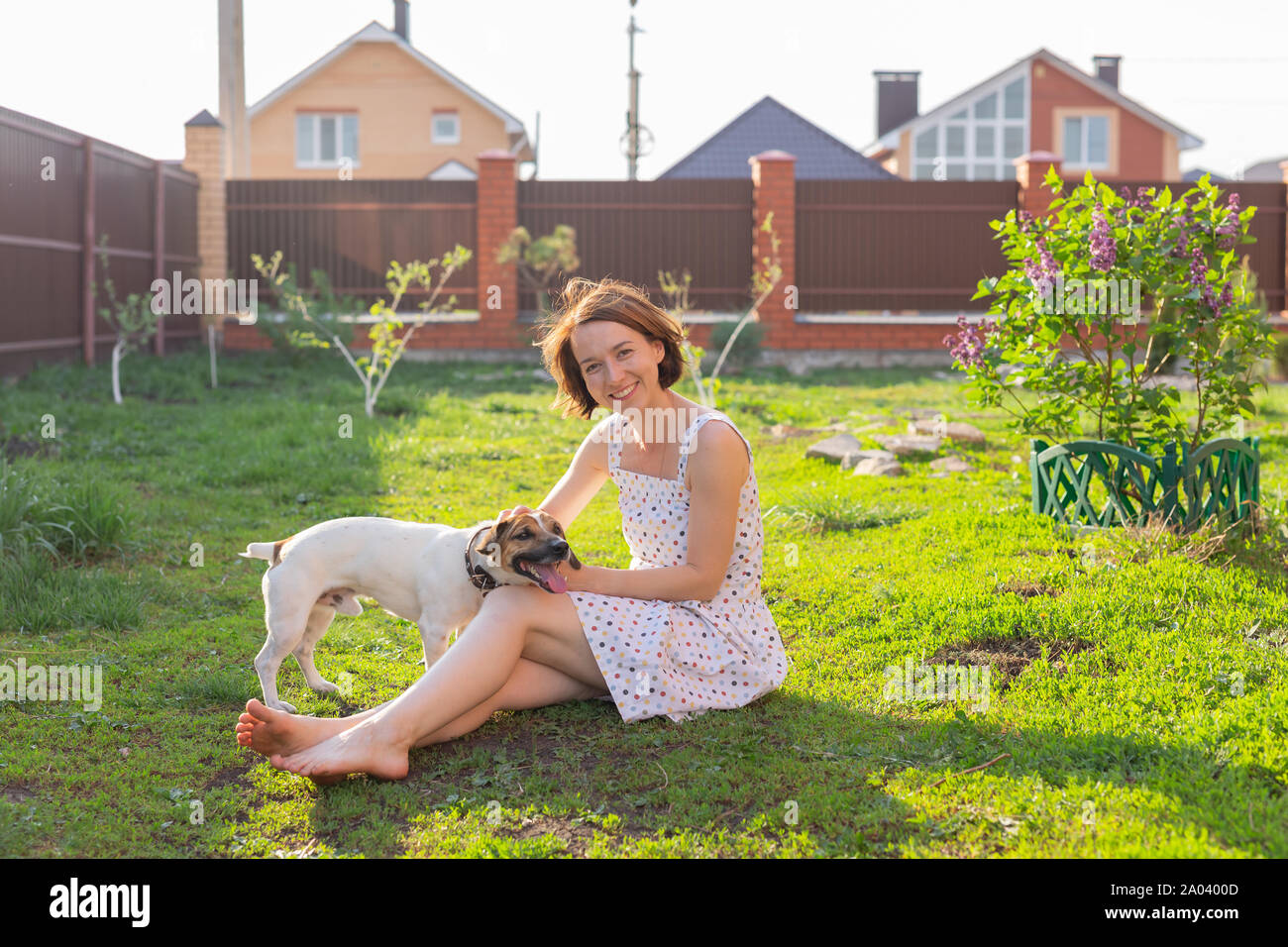 Young woman with her dog playing on the grass outside Stock Photo - Alamy