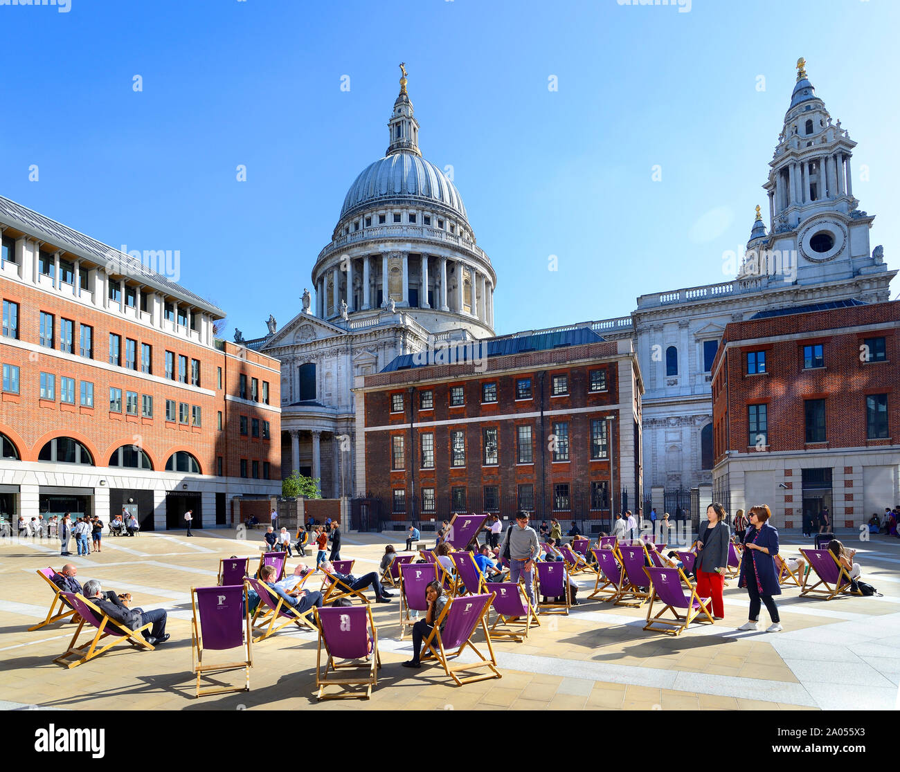 London, England UK. Paternoster Square, behind St Paul's Cathedral. People sitting in deck chairs during their lunch hour Stock Photo