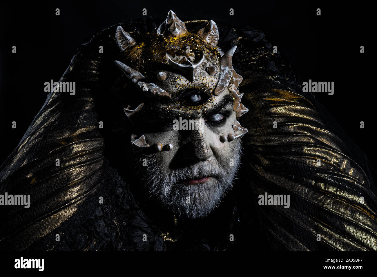 Premium Photo  Monster with thorns and red dragon skin stern demon face  with evil look isolated on black background man with fancy makeup halloween  concept