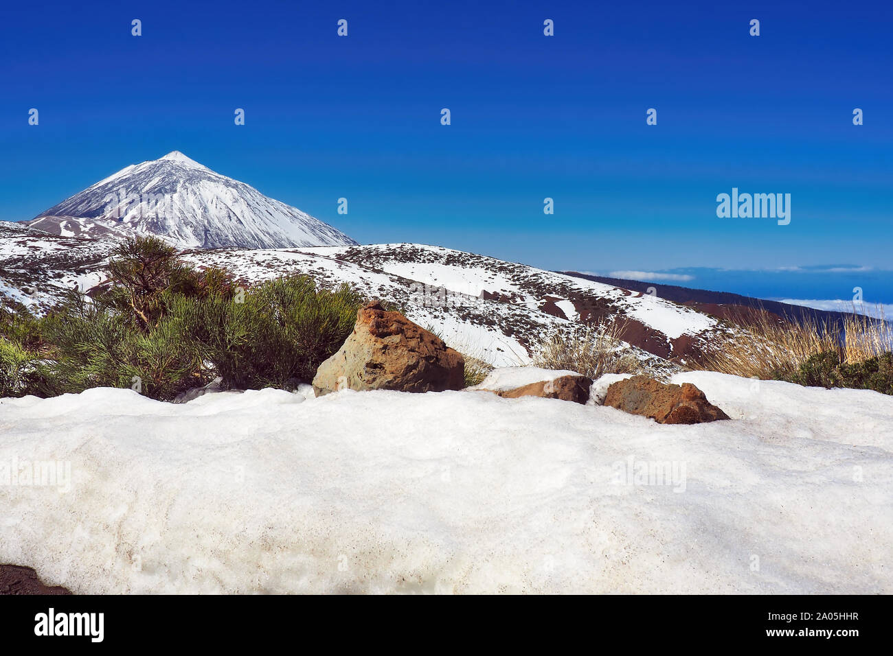 The highest mountain of Spain, the Pico El Teide on Tenerife with high fresh snow and dark blue sky . Stock Photo