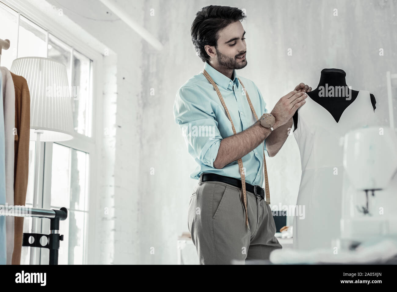 Professional young stylist working with white textile Stock Photo
