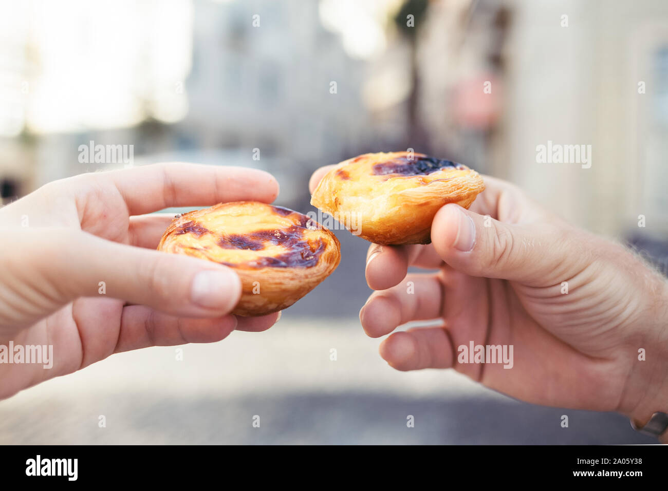 traditional-portuguese-desserts-in-woman-s-and-man-s-hands-pastel-de