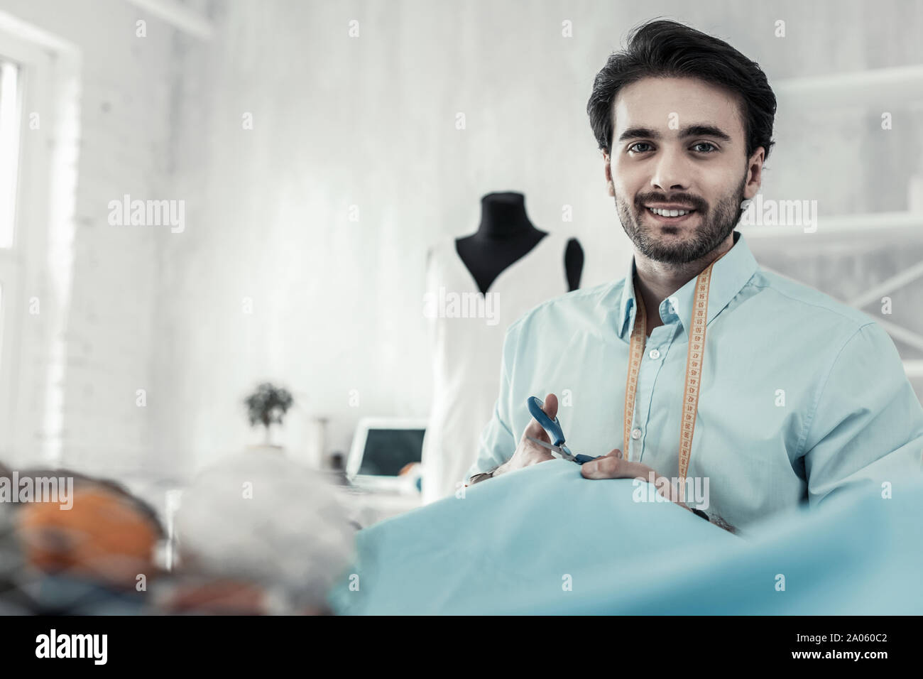Positive delighted tailor working with great pleasure Stock Photo - Alamy