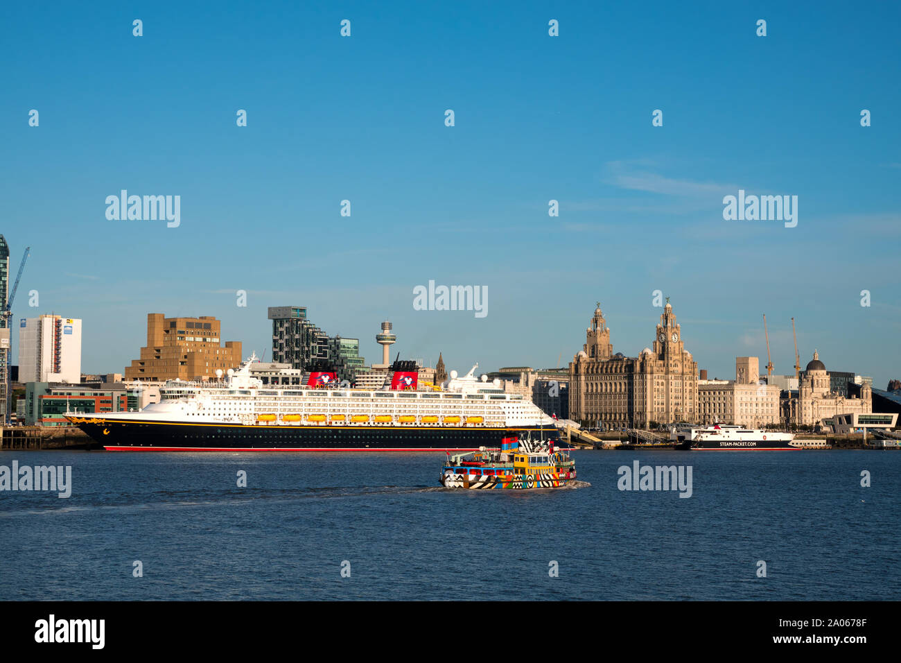 The Mersey Ferry passes the cruise ship Disney Magic after it calls