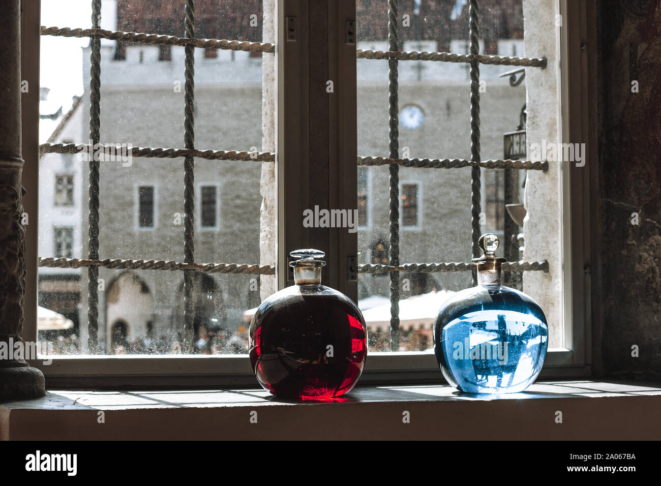 Two bottles with red and blue liquid on the window sill of the old pharmacy, Tallinn, Estonia. Stock Photo