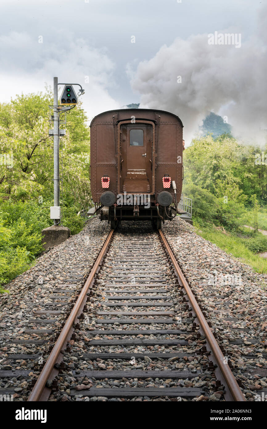 Vintage steam train with ancient locomotive and old carriages runs on the tracks in the countryside Stock Photo