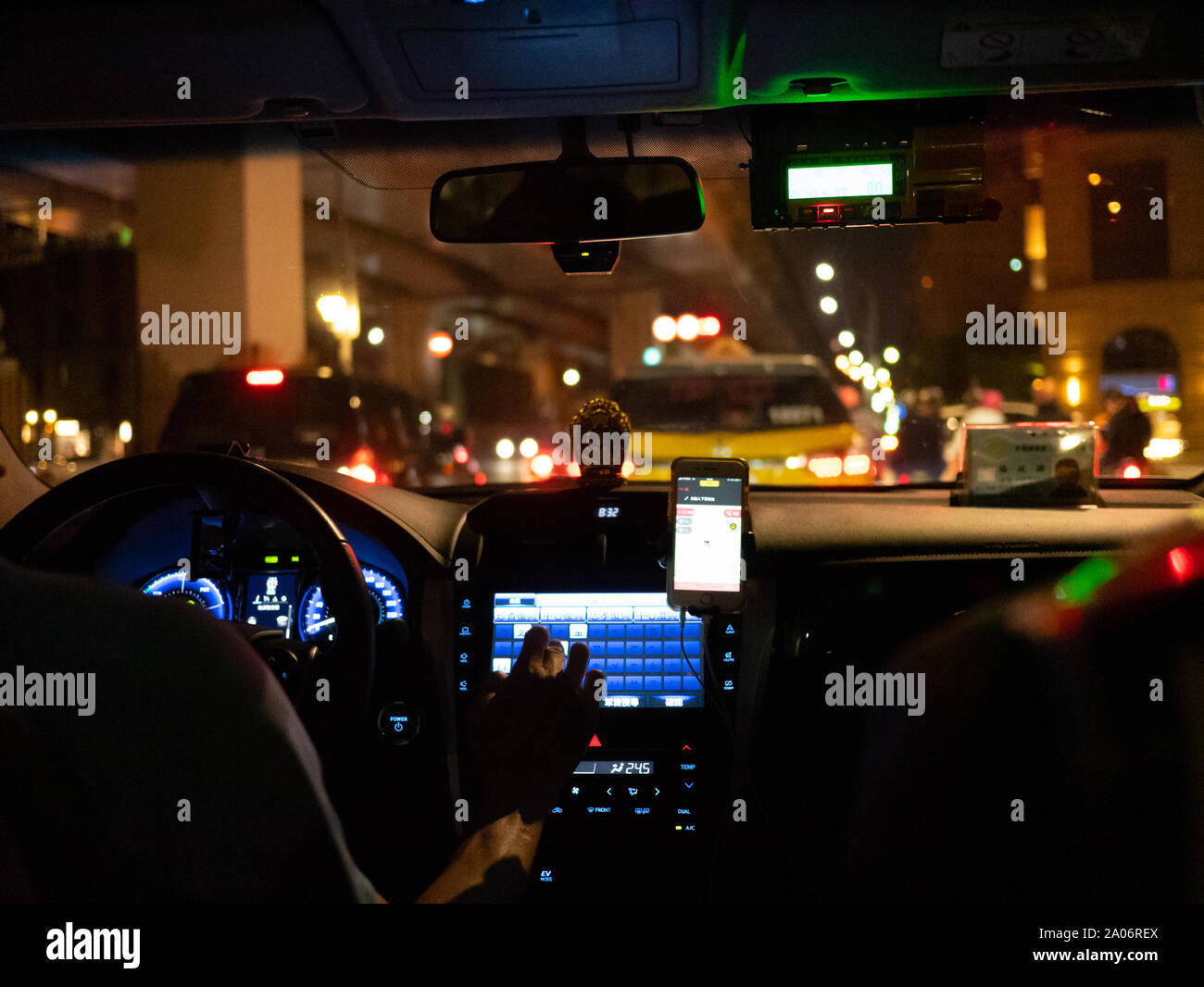 Taipei, Taiwan: Inside view of a taiwanese Taxi at night in the city. Driver using Touchdisplay device / Navigation Stock Photo