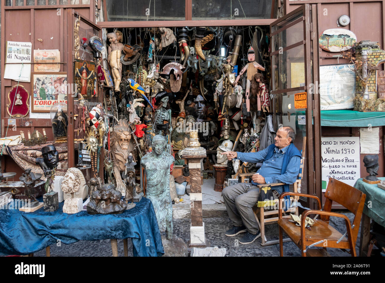 Shopkeeper sitting outside Naples junk shop Stock Photo