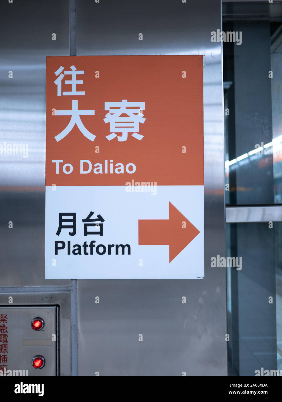 Orange direction sign in Kaohsiung MRT Metro Station giving directions to Daliao Platform in Chinese and english translation on metal wall Stock Photo
