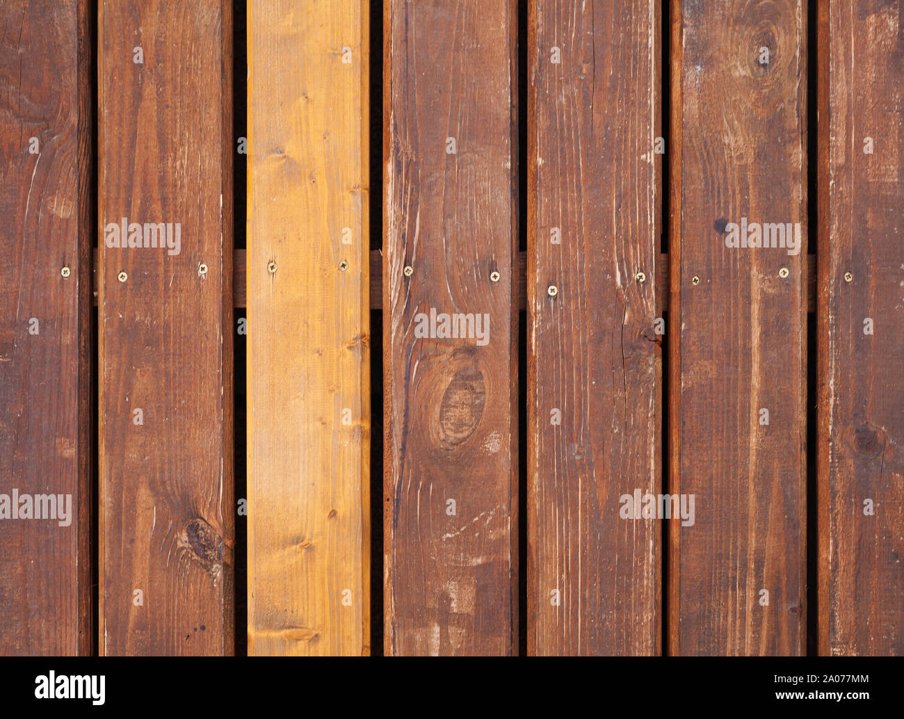 Old brown outdoor wooden floor with one new board, background photo texture Stock Photo
