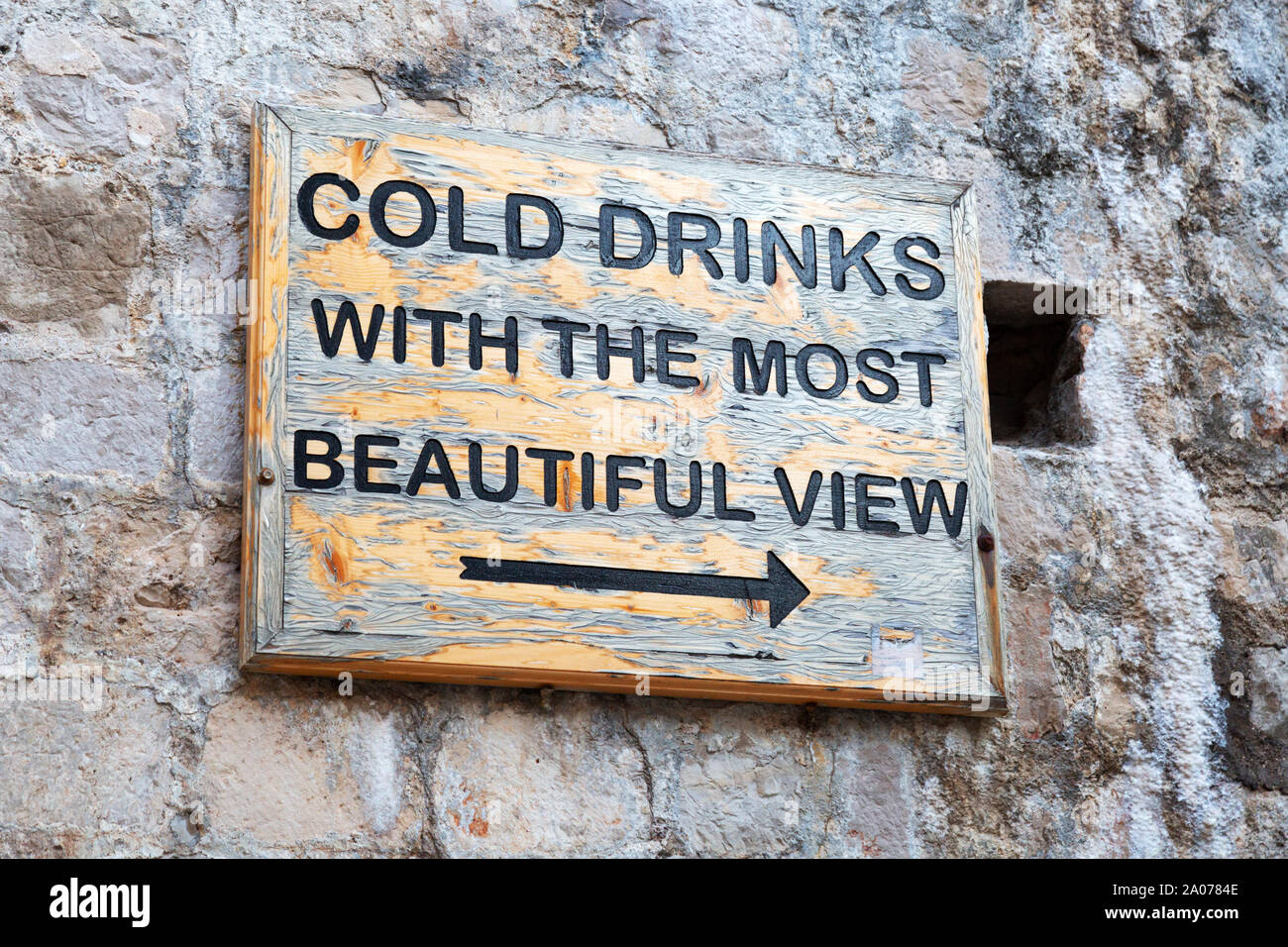 Well known sign "Cold drinks with the most beautiful view" giving directions to the Buza bar for sunset drinks; Dubrovnik old town, Croatia Europe Stock Photo