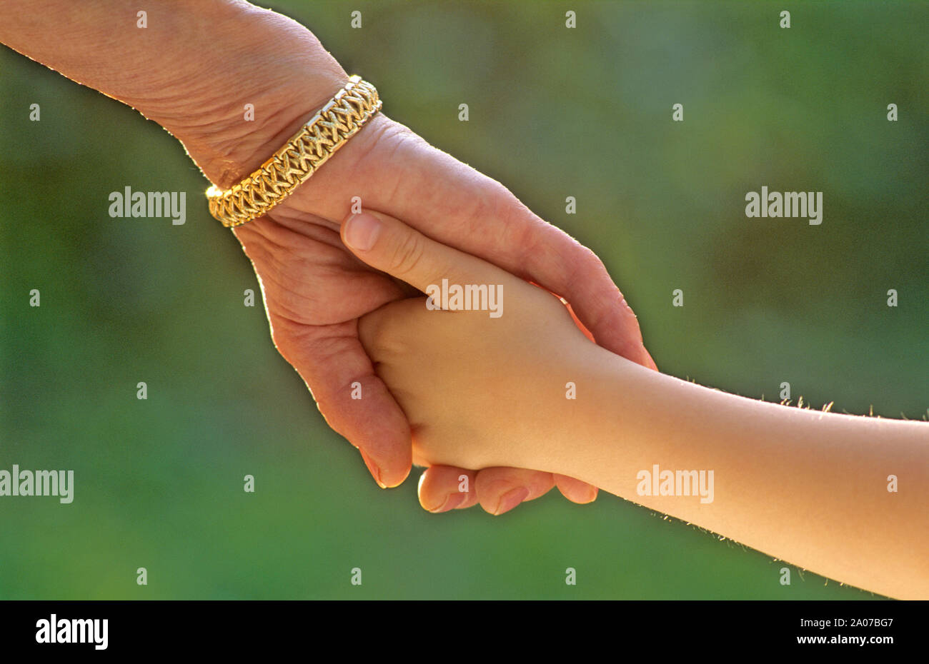 Grandmother holding hands with her granddaughter outdoors close up Stock Photo