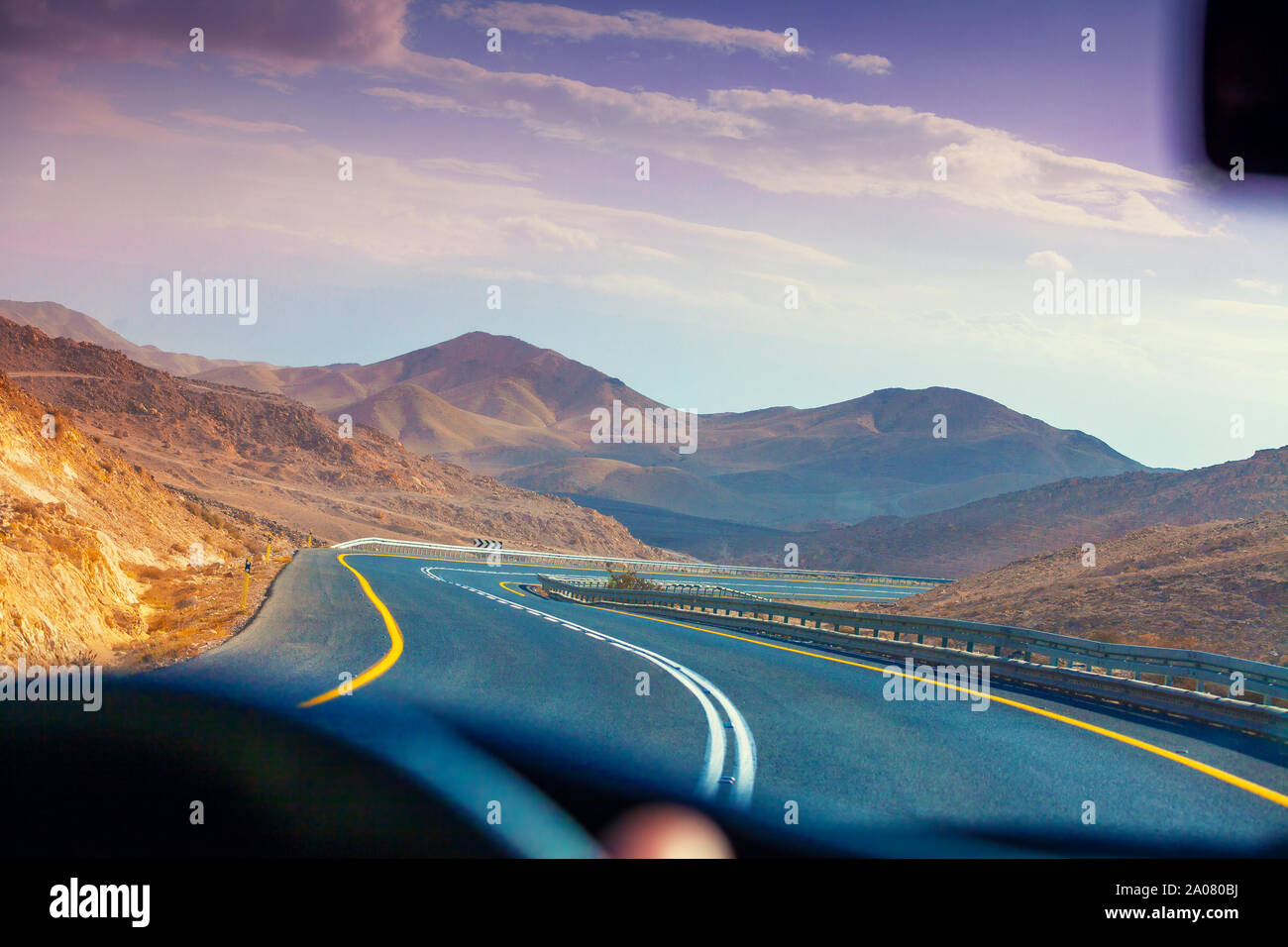 Driving a car on the mountain road in the desert. View of sandstone ...