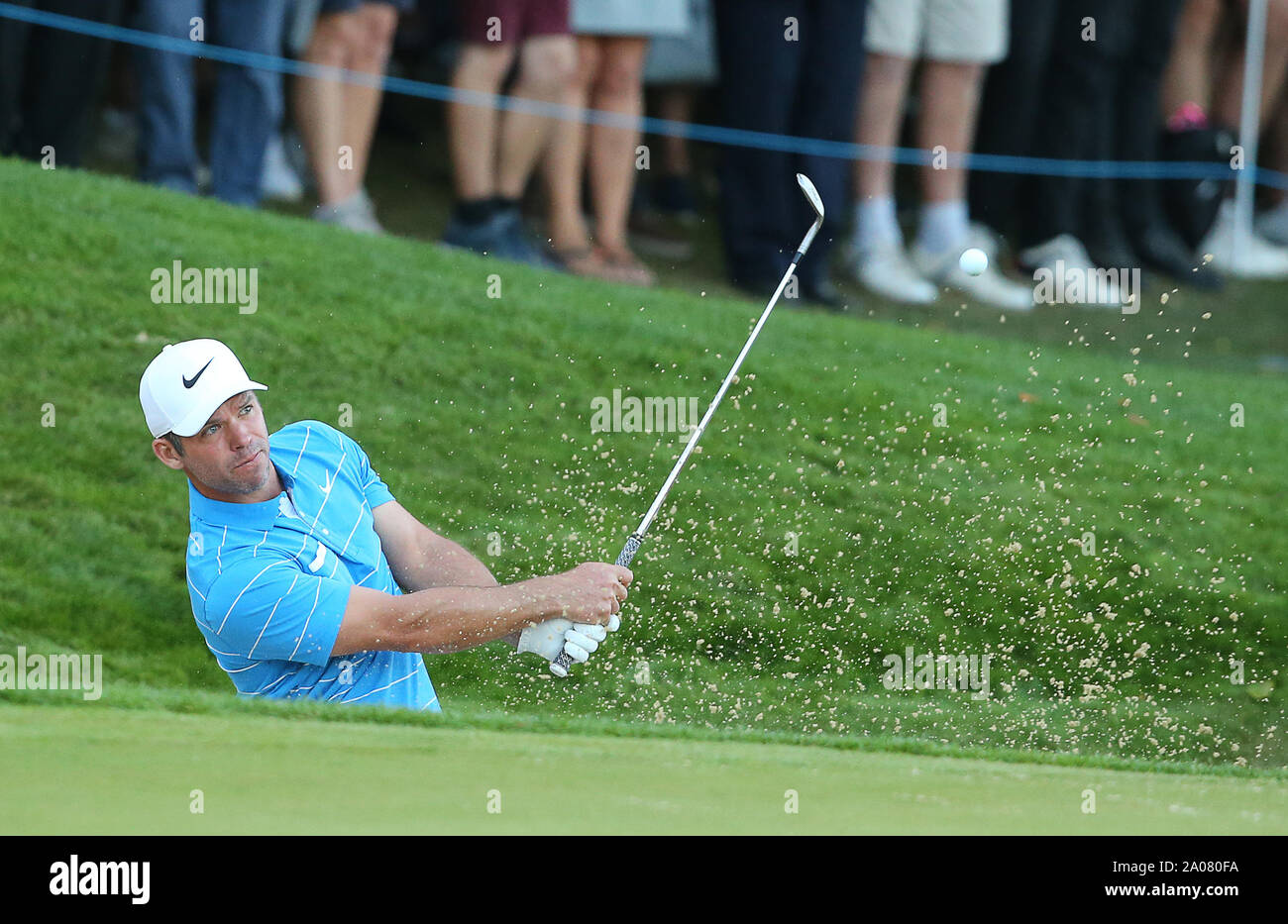 Wentworth Golf Club, Virginia Water, UK. 19 September 2019. Paul Casey of England plays a bunker shot on the 18th hole which goes into the water hazard during Day 1 at the BMW PGA Championship. Editorial use only. Credit: Paul Terry/Alamy. Credit: Paul Terry Photo/Alamy Live News Stock Photo