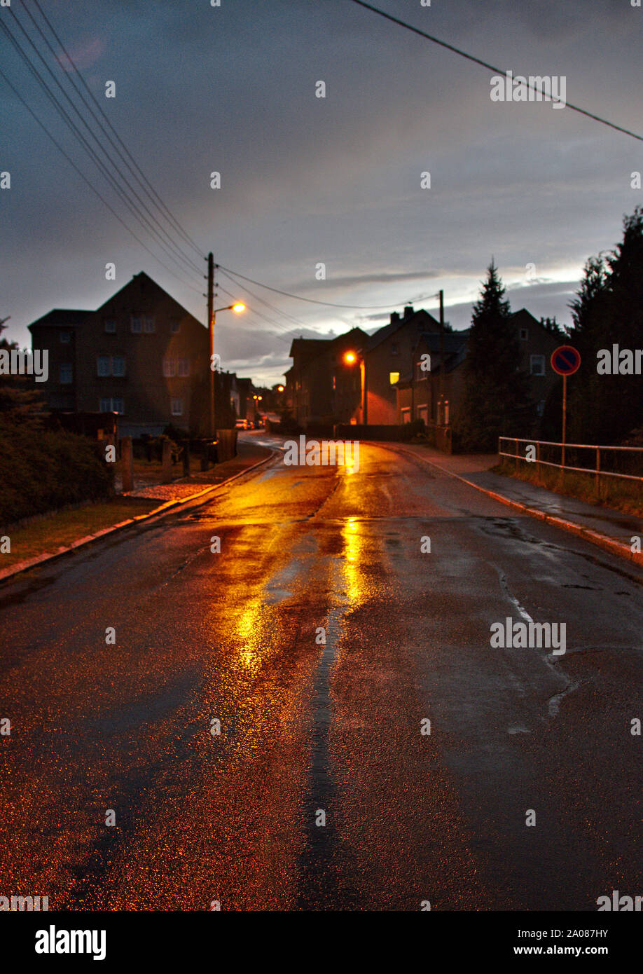 wet street reflecting lights of the streetlamps Stock Photo