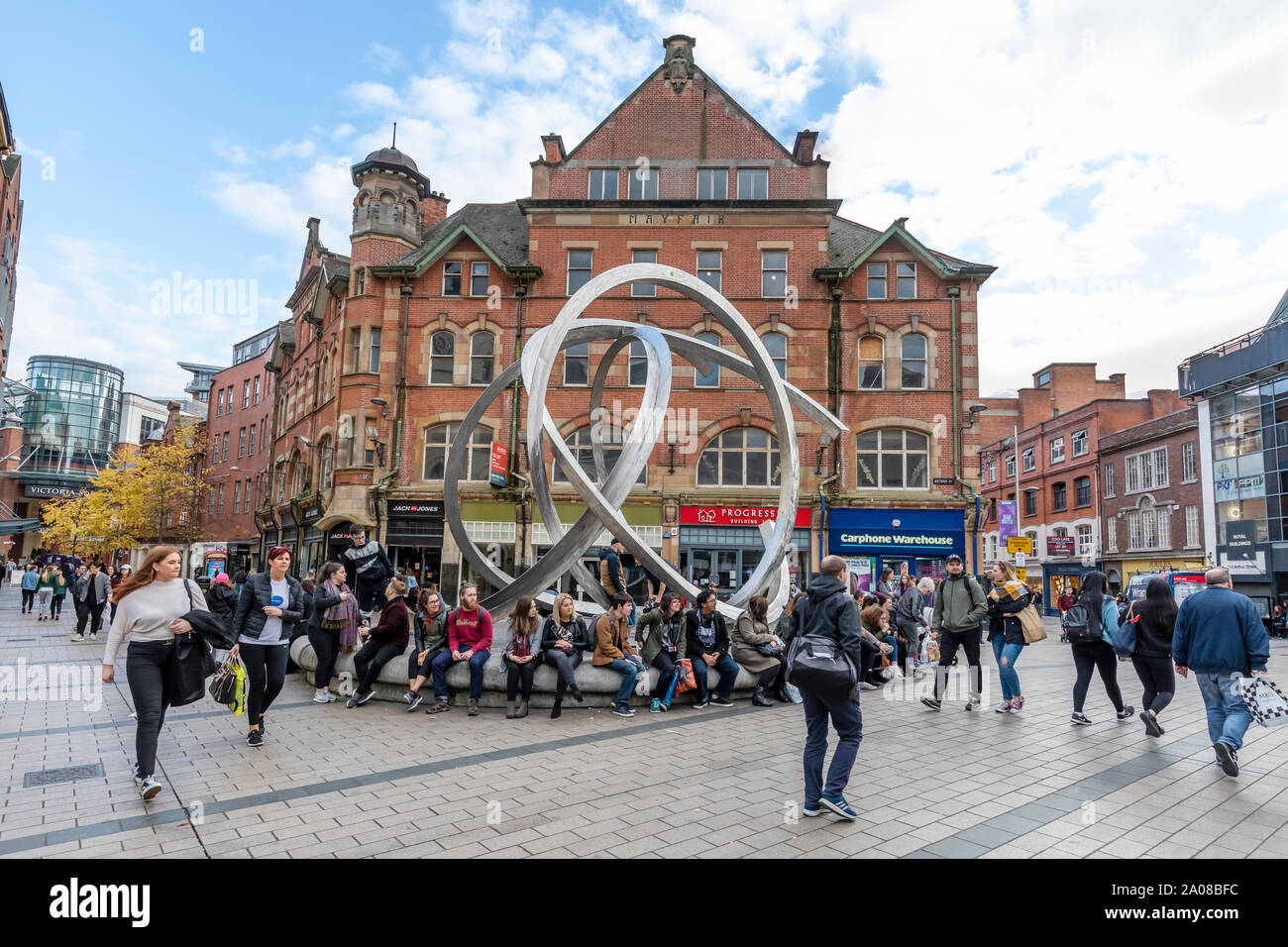People and pedestrians walking about and enjoying themselves by Williams Street South surrounded by many retail stores in Belfast, Northern Ireland. Stock Photo
