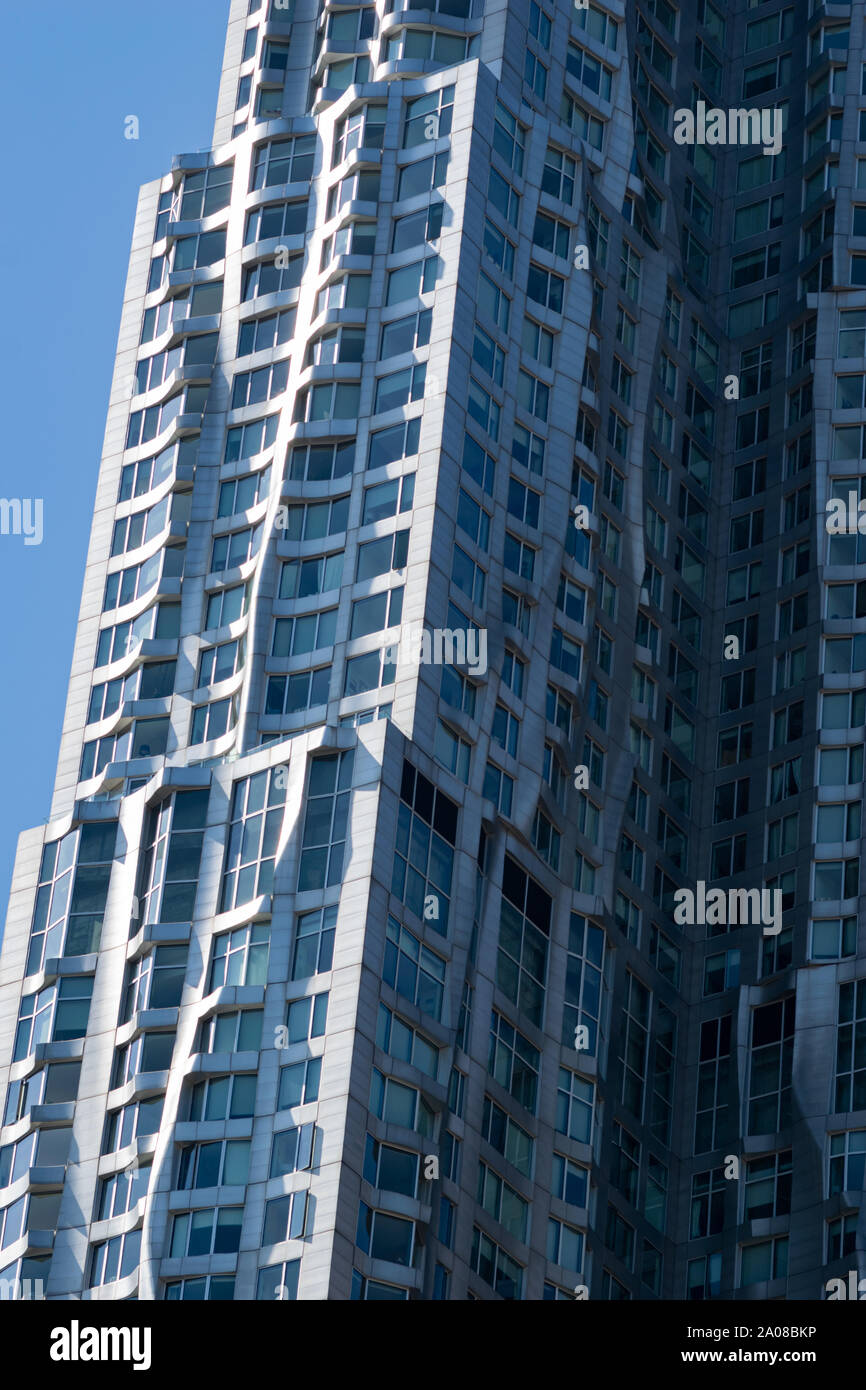 Von der Morgensonne angestrahlte Detailansicht vom Frank Gehry-Hochhaus in NYC in Manhattan. Beeindruckende moderne Architektur silber glänzend mit vi Stock Photo