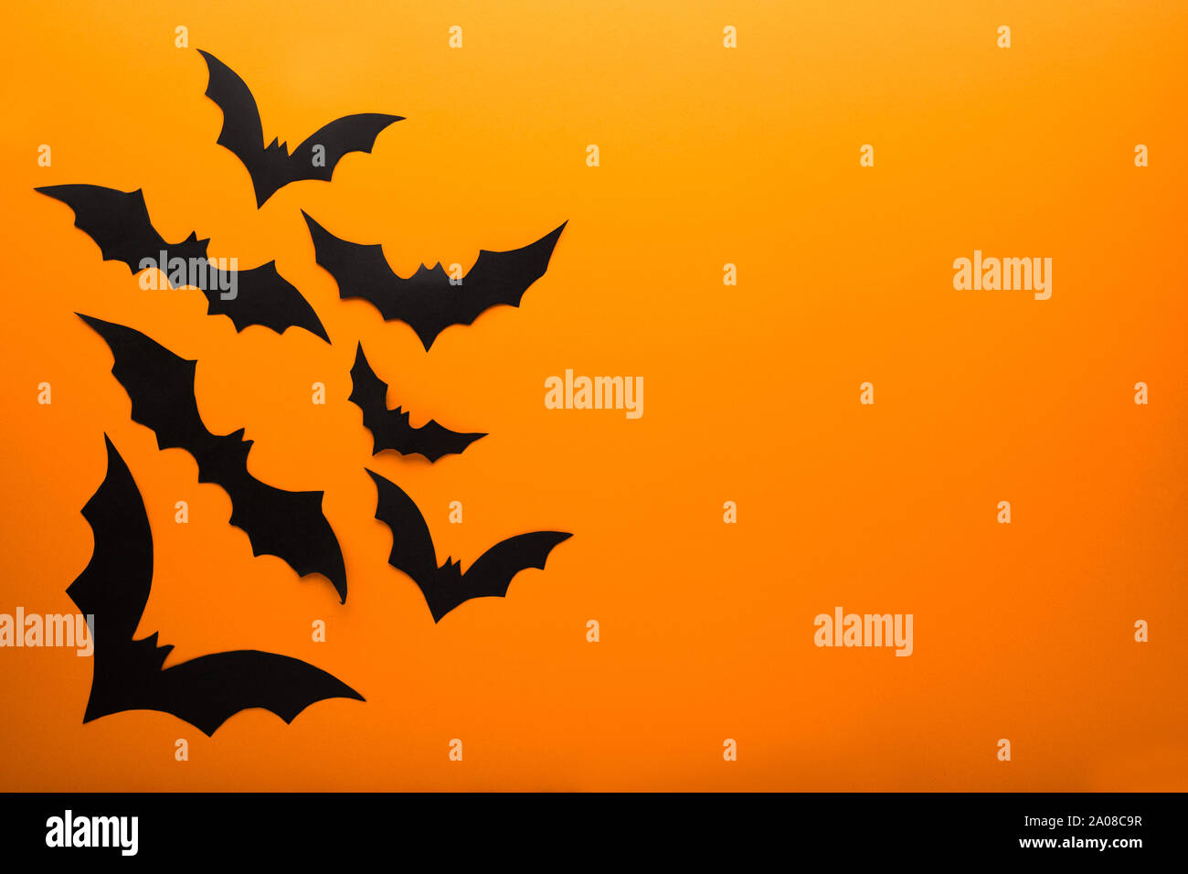 Halloween and decoration concept - black paper bats flying over orange ...