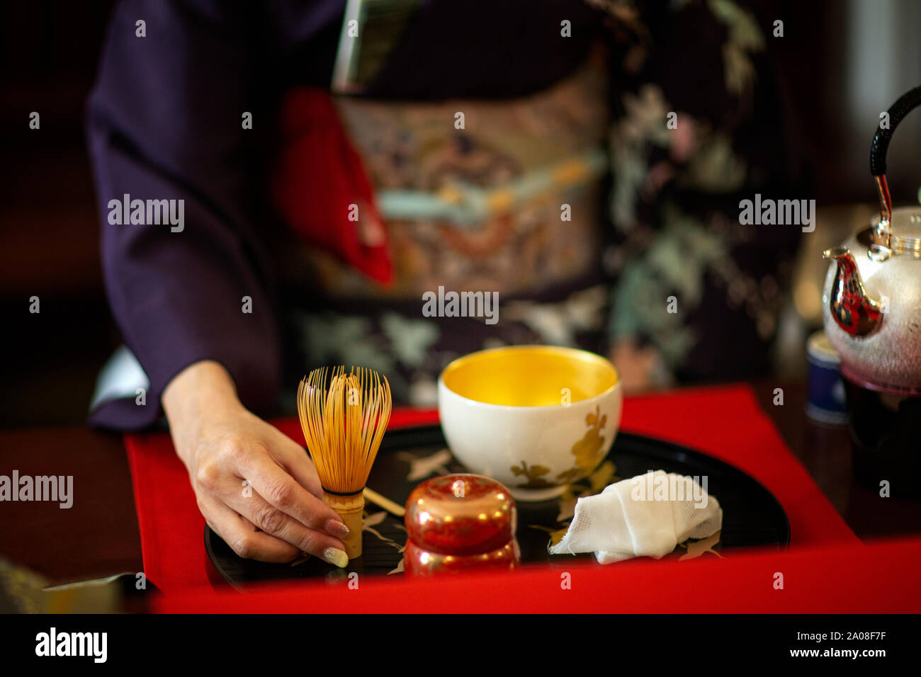 A woman wearing a kimono during a traditional Japanese tea ceremony Stock Photo