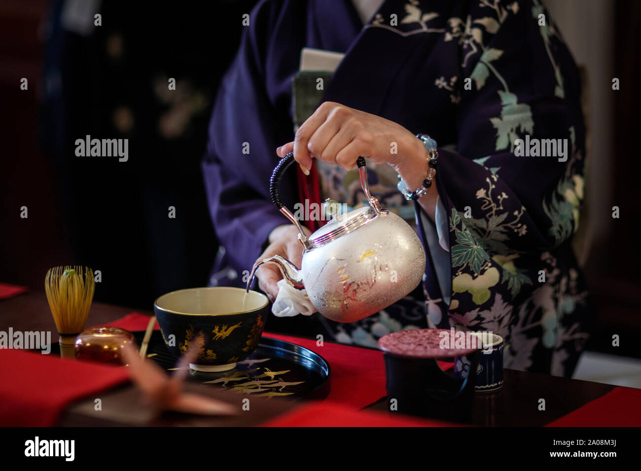 A woman wearing a kimono during a traditional Japanese tea ceremony ...