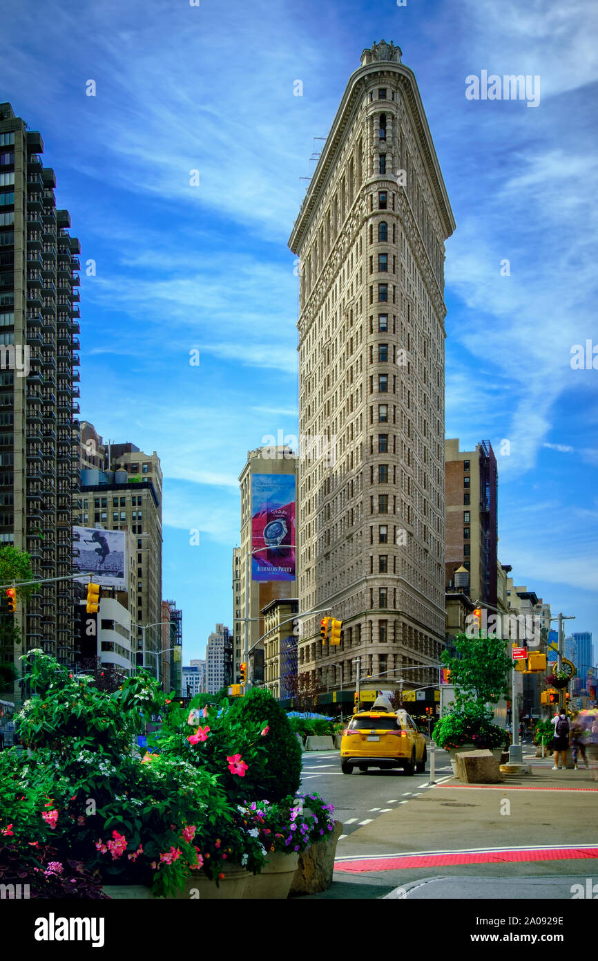 2019 August 31, New York City, USA - Yellow taxi head downtown on Broadway past the iconic Flatiron Building Stock Photo