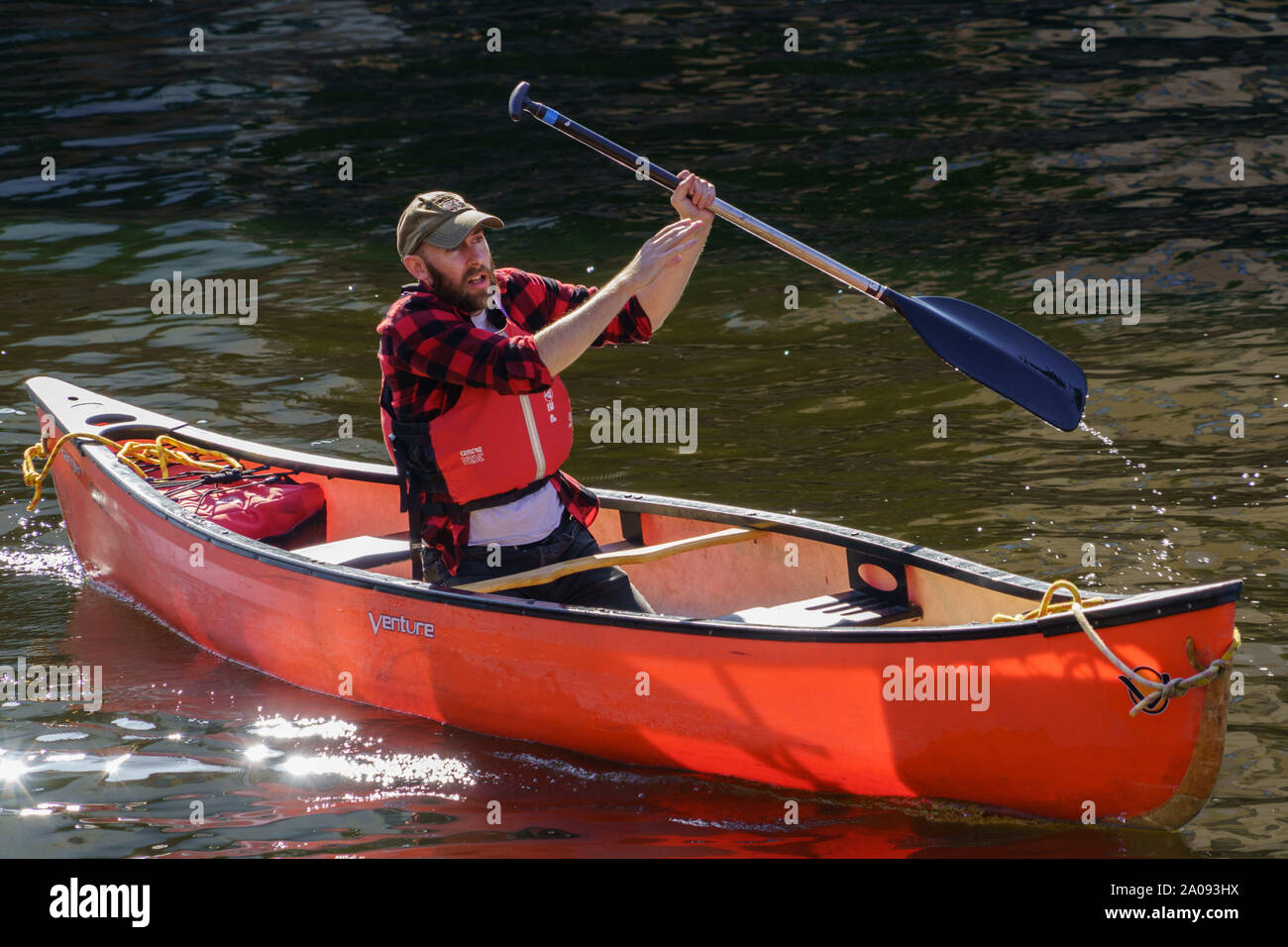 Man in a red Canoe rowing along The River Aire, Leeds, West Yorkshire